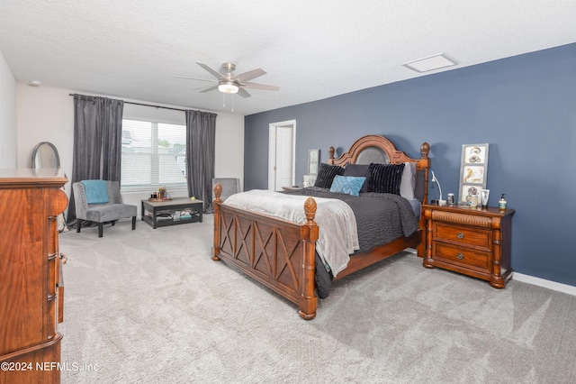 bedroom with baseboards, light colored carpet, a textured ceiling, and a ceiling fan