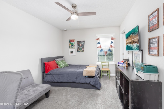 carpeted bedroom with a textured ceiling and ceiling fan