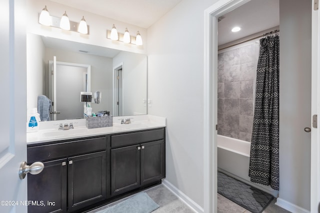 bathroom with double vanity, shower / tub combo with curtain, baseboards, and a sink