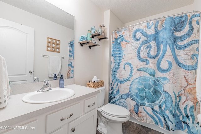 full bath featuring a textured ceiling, curtained shower, toilet, wood finished floors, and vanity