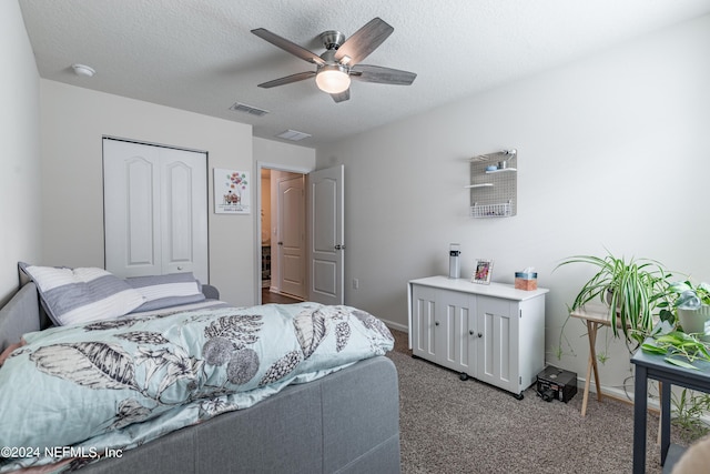 carpeted bedroom with baseboards, a textured ceiling, visible vents, and a closet