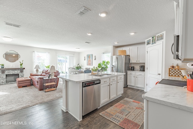 kitchen featuring visible vents, a fireplace, appliances with stainless steel finishes, and white cabinets