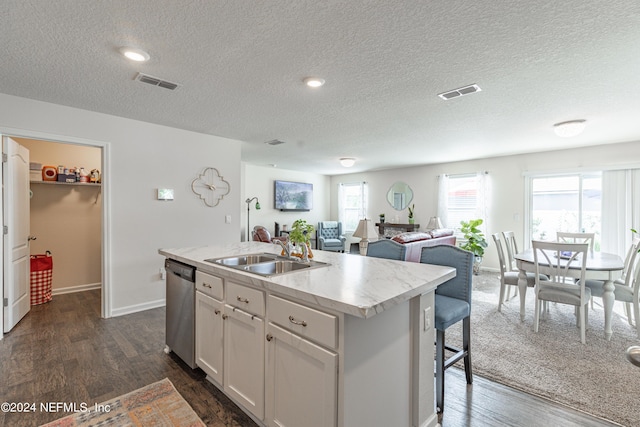 kitchen with a kitchen island with sink, visible vents, dishwasher, and a sink