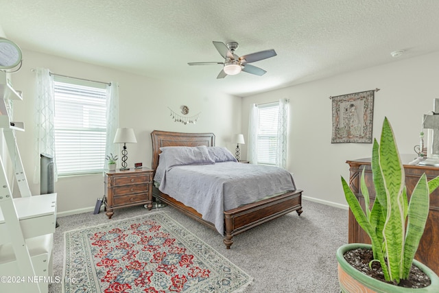 bedroom with a ceiling fan, carpet flooring, a textured ceiling, and baseboards