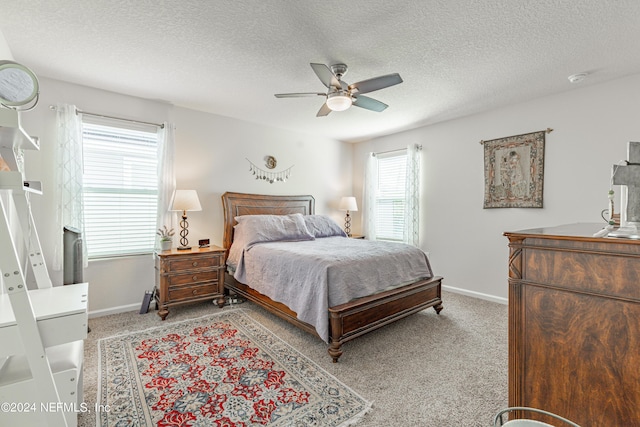 bedroom featuring a ceiling fan, carpet flooring, a textured ceiling, and baseboards