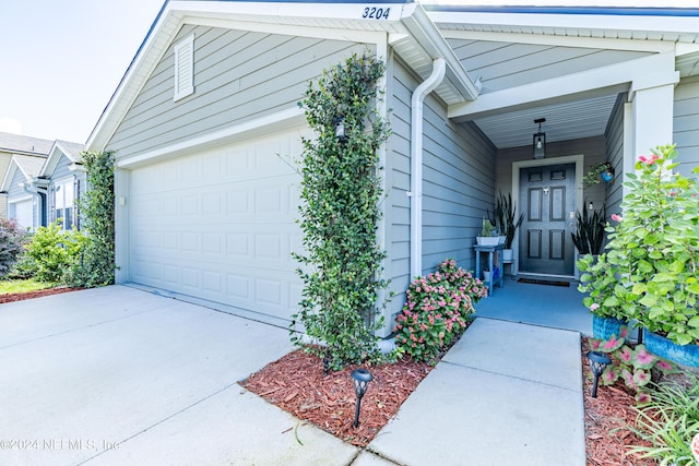 doorway to property with concrete driveway and an attached garage