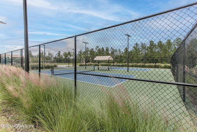 view of sport court featuring fence