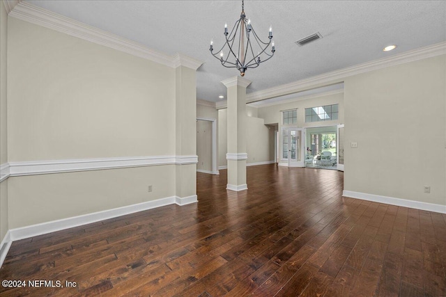 unfurnished dining area featuring hardwood / wood-style flooring, visible vents, baseboards, ornamental molding, and decorative columns