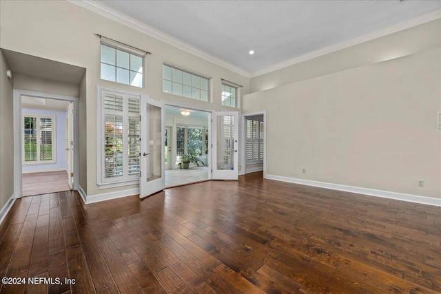 unfurnished living room featuring a healthy amount of sunlight, dark wood finished floors, and baseboards