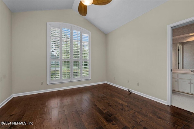 unfurnished room featuring lofted ceiling, a sink, baseboards, and hardwood / wood-style flooring