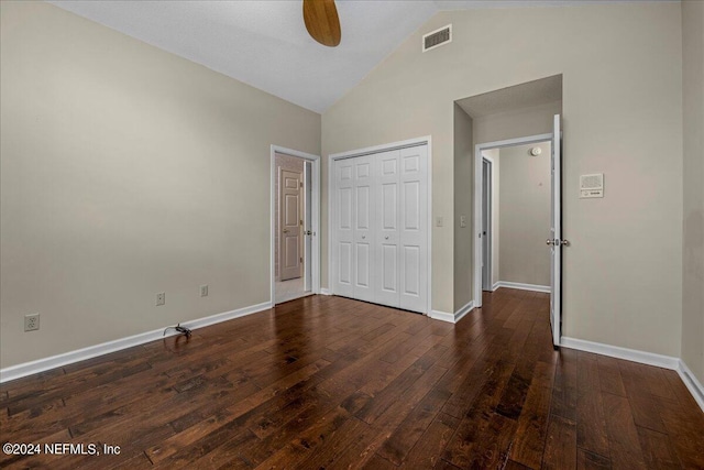 unfurnished bedroom featuring dark wood-style floors, a closet, visible vents, high vaulted ceiling, and baseboards