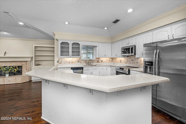 kitchen with visible vents, appliances with stainless steel finishes, a kitchen breakfast bar, ornamental molding, and a sink