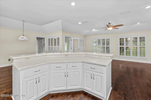 kitchen featuring lofted ceiling, pendant lighting, white cabinets, and dark wood finished floors