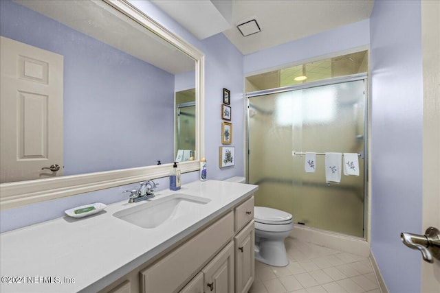 bathroom featuring a stall shower, tile patterned flooring, vanity, and toilet