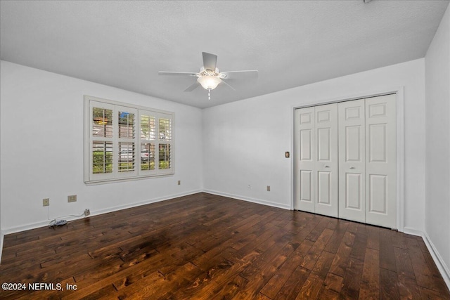 unfurnished bedroom with baseboards, a ceiling fan, dark wood-style floors, a textured ceiling, and a closet