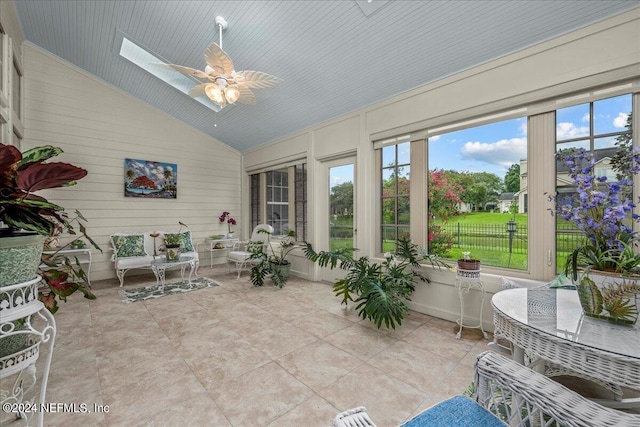 sunroom / solarium featuring ceiling fan and vaulted ceiling with skylight