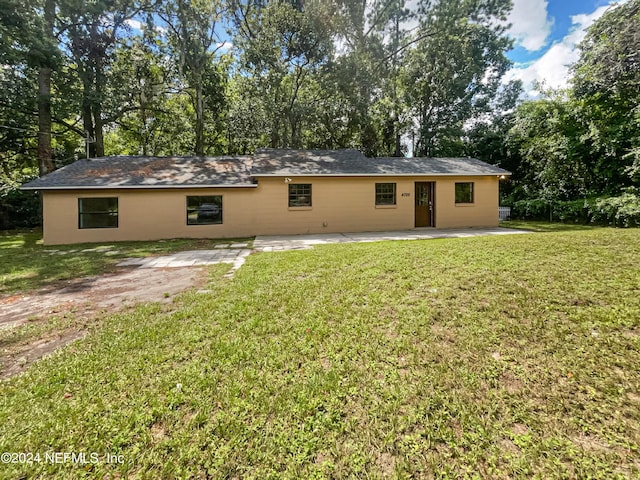 rear view of property with a yard and a patio