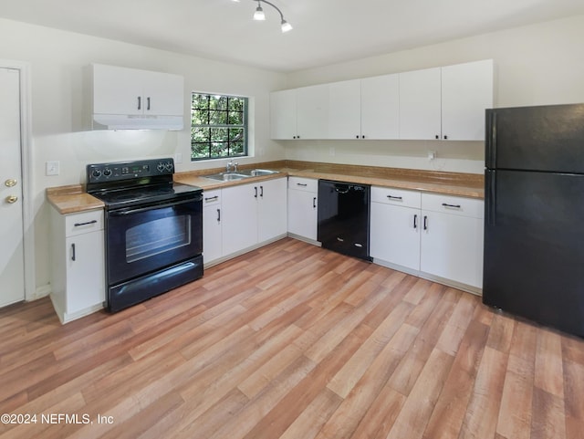 4026 Capper Rd, Jacksonville, FL 32218 - kitchen featuring under cabinet range hood, a sink, white cabinetry, light wood-type flooring, and black appliances