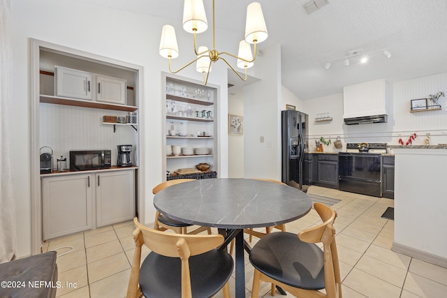 tiled dining room with an inviting chandelier and a textured ceiling