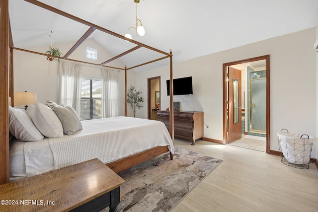 bedroom with light wood-type flooring, vaulted ceiling, a chandelier, and ensuite bathroom