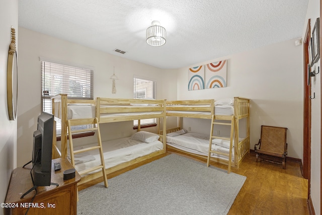 bedroom with wood-type flooring and a textured ceiling