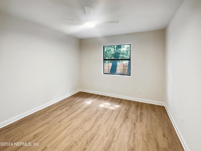 spare room with ceiling fan, baseboards, and wood finished floors