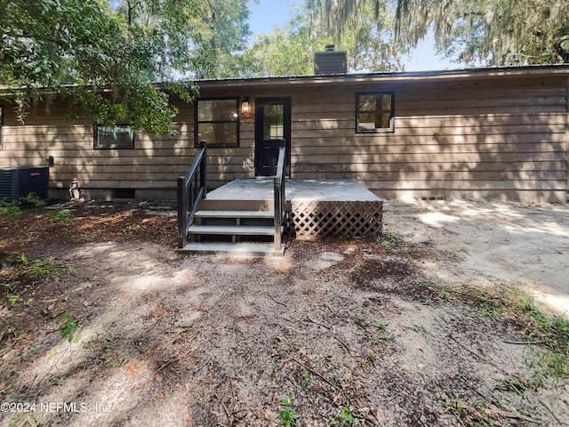 entrance to property with crawl space, a chimney, a deck, and central AC