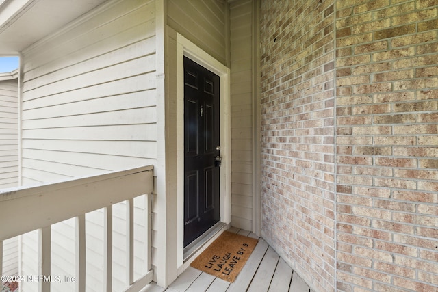 view of exterior entry with brick siding