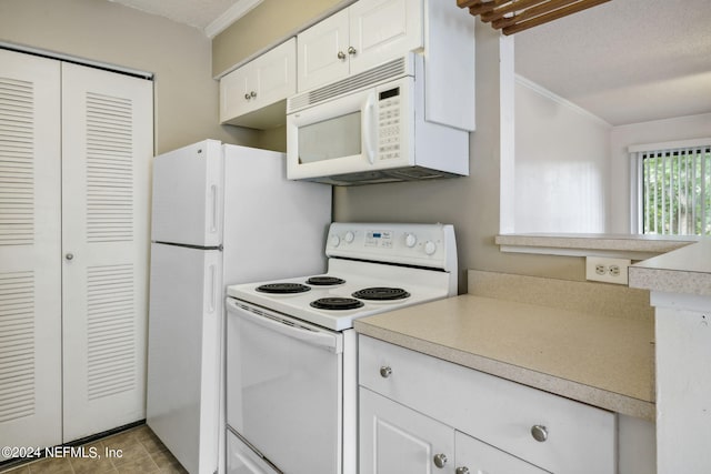 kitchen featuring white appliances, light countertops, a textured ceiling, crown molding, and white cabinetry