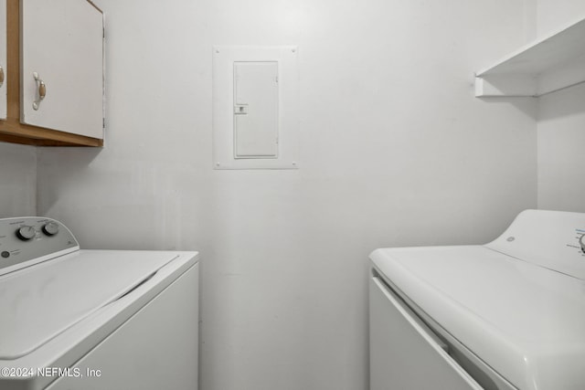 clothes washing area featuring cabinet space, washing machine and clothes dryer, and electric panel