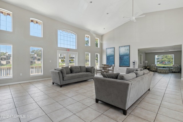 living room with light tile patterned floors, french doors, vaulted ceiling, and baseboards