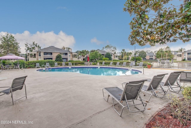 pool with a patio area and fence