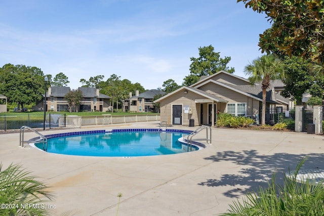 community pool featuring a patio and fence