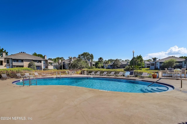 pool featuring a patio and a residential view