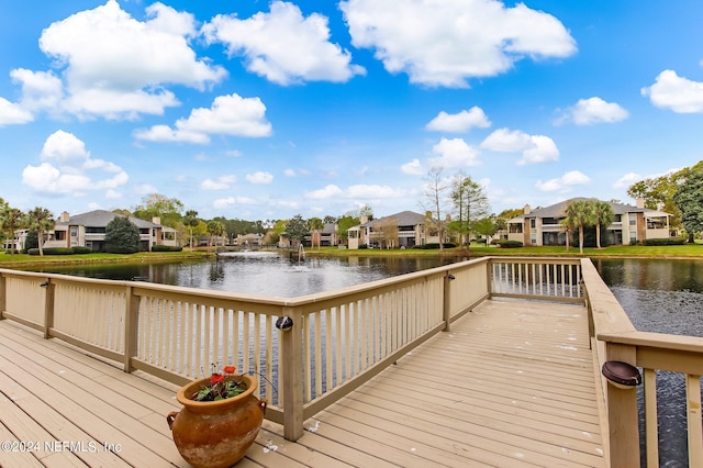 view of dock with a deck with water view and a residential view