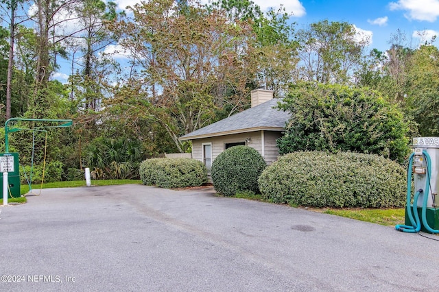 exterior space with a shingled roof and a chimney