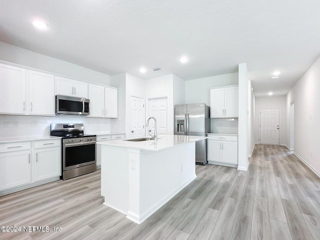 kitchen featuring sink, white cabinets, light hardwood / wood-style flooring, and appliances with stainless steel finishes