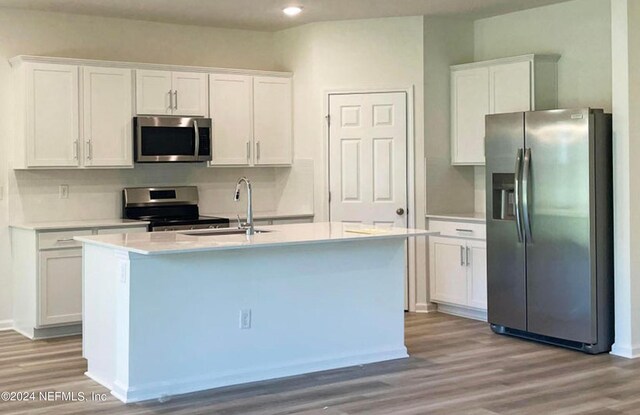 kitchen featuring white cabinets, wood-type flooring, and stainless steel appliances