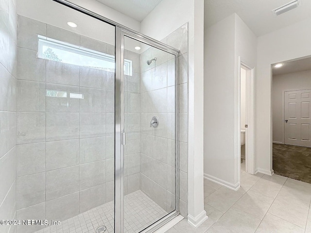 bathroom with a stall shower, visible vents, baseboards, and tile patterned floors