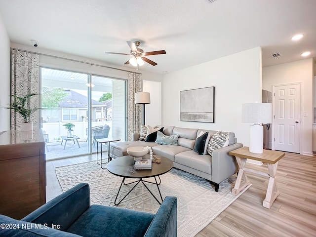 living room featuring light wood-type flooring, ceiling fan, visible vents, and recessed lighting