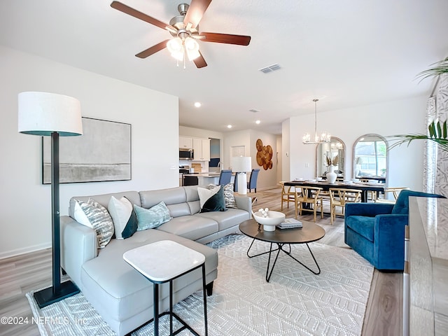 living area with recessed lighting, ceiling fan with notable chandelier, visible vents, baseboards, and light wood finished floors