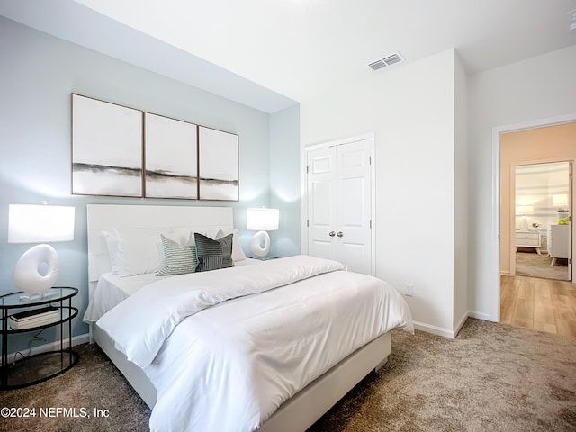 bedroom with carpet floors, baseboards, visible vents, and a closet