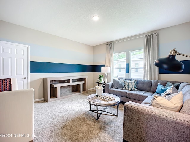 carpeted living area with a textured ceiling and baseboards