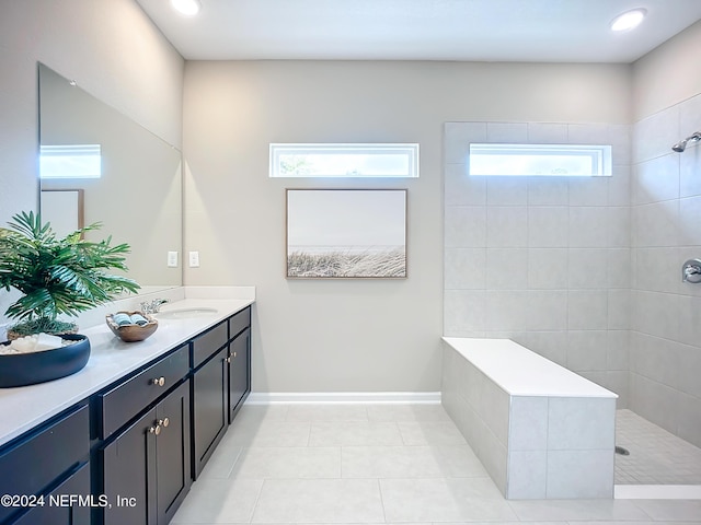 full bath featuring a sink, baseboards, tile patterned floors, double vanity, and walk in shower