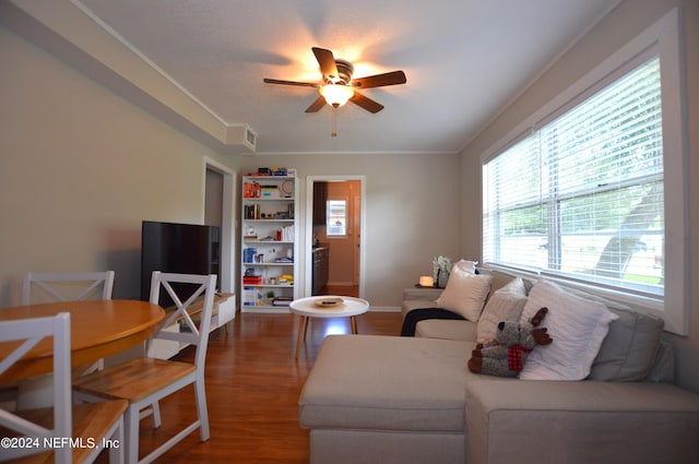 living room featuring ceiling fan, ornamental molding, and hardwood / wood-style flooring