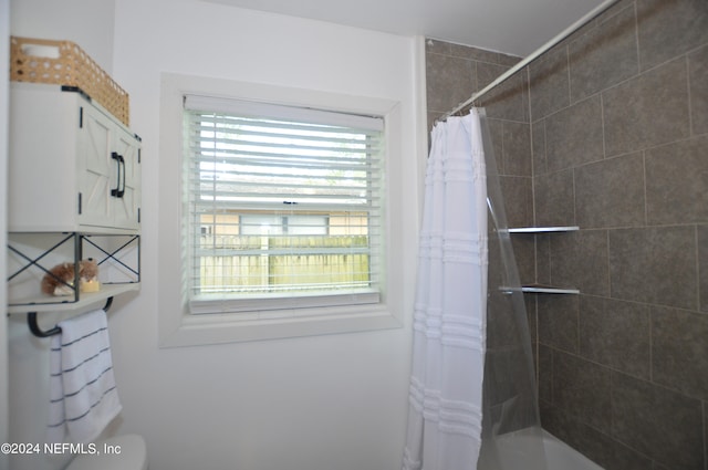 bathroom with a wealth of natural light and shower / bath combination with curtain