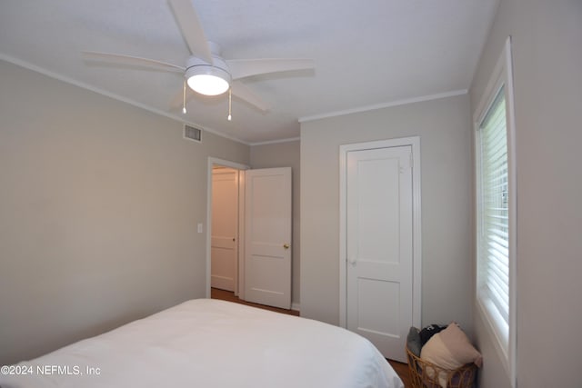 bedroom with ceiling fan and crown molding