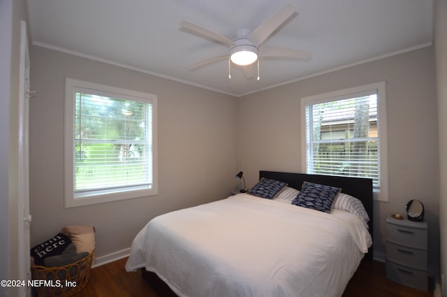 bedroom with ceiling fan, crown molding, and dark wood-type flooring