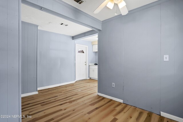 spare room featuring hardwood / wood-style floors, ceiling fan, and beamed ceiling