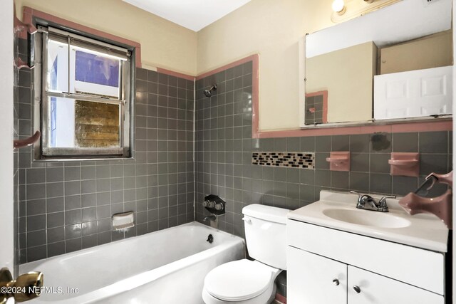 full bathroom featuring vanity, tasteful backsplash, tile walls, toilet, and tiled shower / bath combo